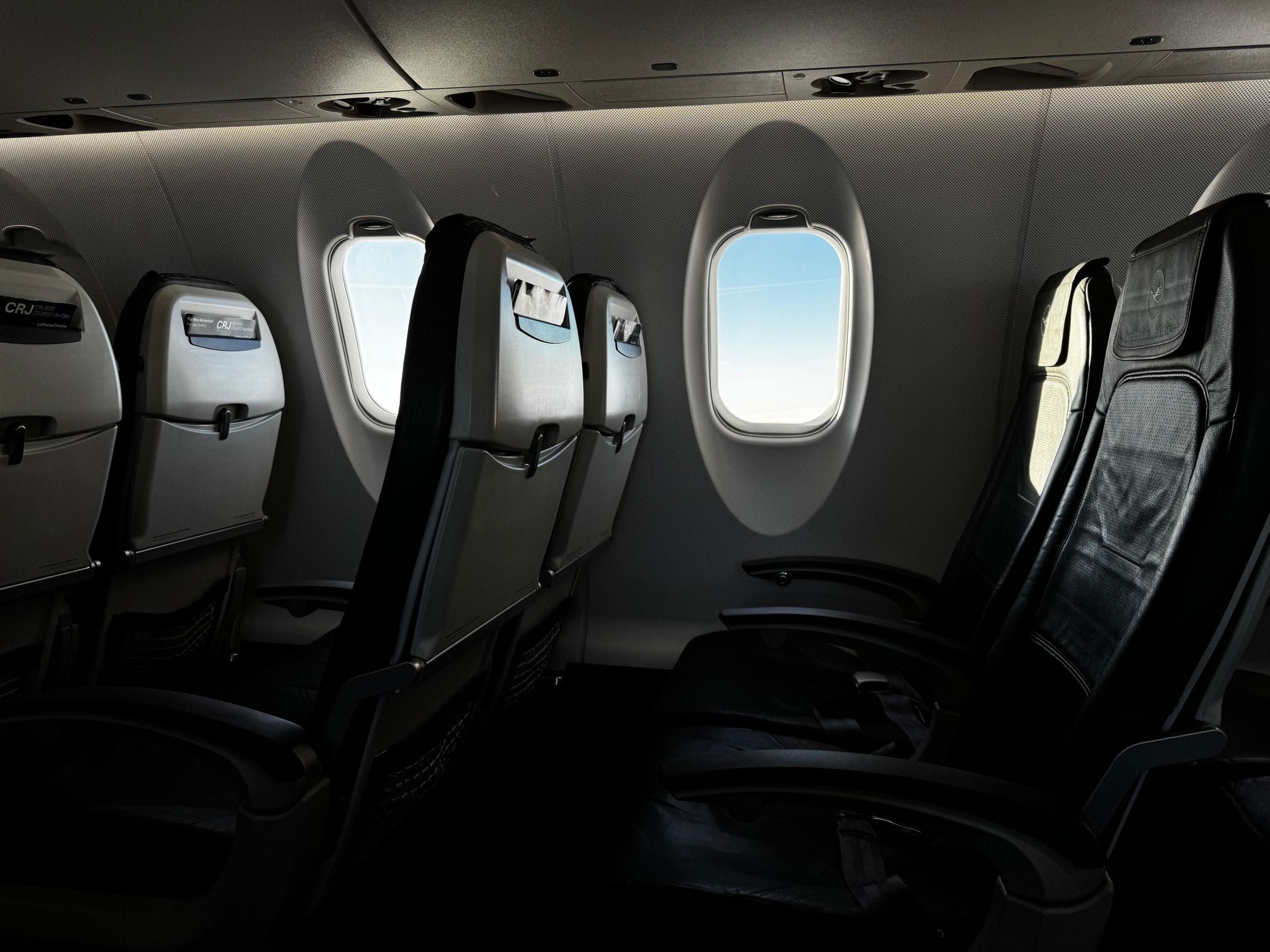 Cabina de una aeronave con los asientos vacíos junto a las ventanillas ovaladas